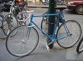 Blue fixed-gear (track) bicycle locked up.JPG